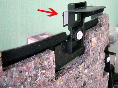 La flèche montre le coté où placer une mousse de 4 x 5 cm environ. Ici, la vue arrière du panneau de moquette de garniture du hayon.